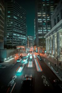 Piste cyclable en ville vue de nuit avec trafic routier et lumières